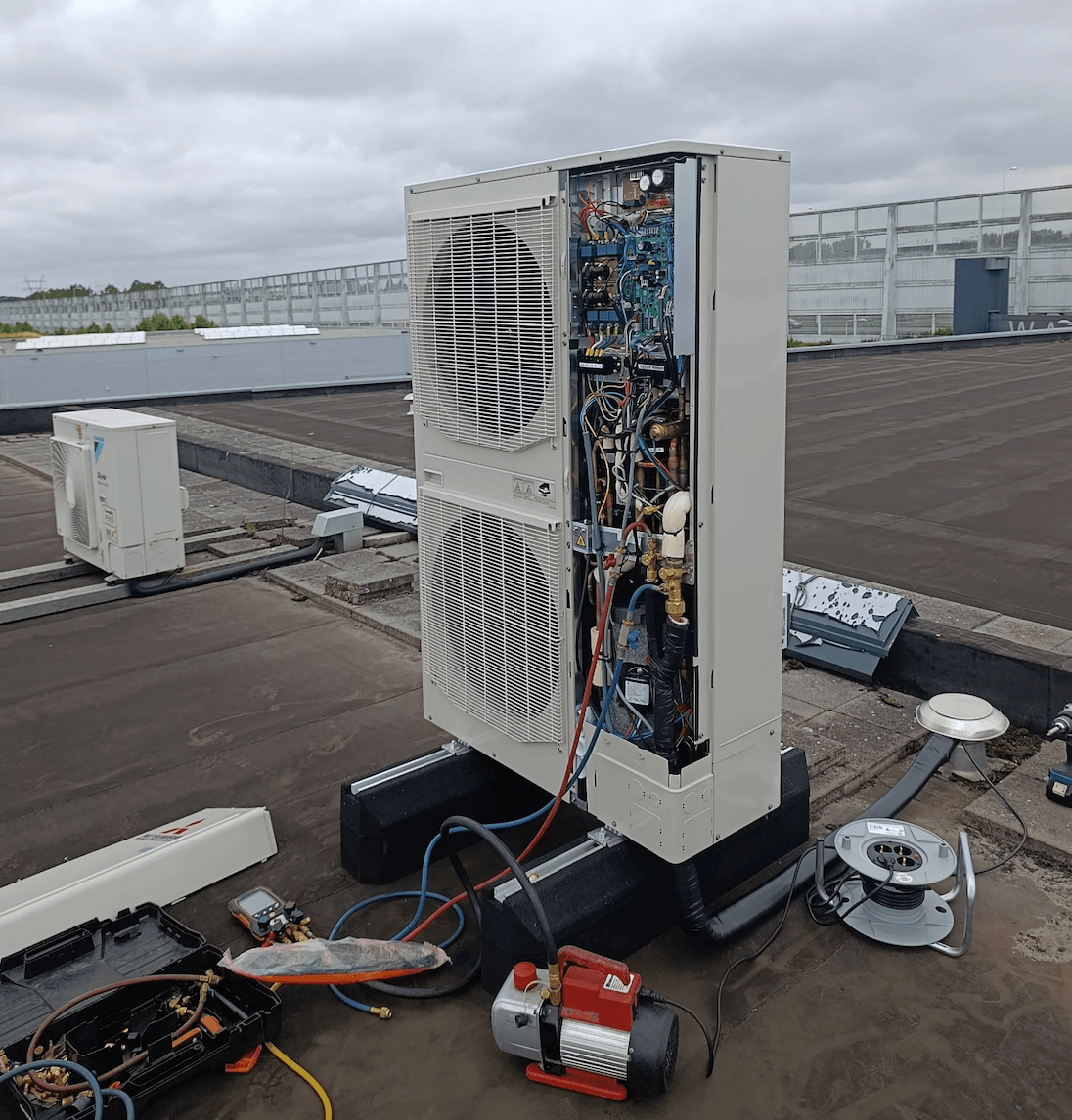 Geopende buitenunit tijdens reparatie op dak